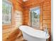 Bathroom featuring a clawfoot tub and two large windows framing the view of the trees outside at 11766 Coal Creek Heights Dr, Golden, CO 80403