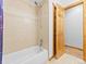 Clean bathroom featuring a bathtub with a showerhead and a partially opened door leading to another room at 11766 Coal Creek Heights Dr, Golden, CO 80403