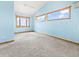 Bright bedroom featuring a light blue wall color, carpeted floor, and wood-trimmed windows offering natural light at 11766 Coal Creek Heights Dr, Golden, CO 80403