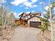 Stunning exterior of a multi-story home with a log cabin-style porch and attached garage at 11766 Coal Creek Heights Dr, Golden, CO 80403