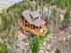 A beautiful mountain home with wood siding, a large deck, and large windows is nestled among the trees at 11766 Coal Creek Heights Dr, Golden, CO 80403