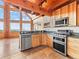 Kitchen with wood cabinetry, stainless steel appliances, granite countertops, and scenic views at 11766 Coal Creek Heights Dr, Golden, CO 80403