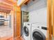Laundry room with washer, dryer, shelving, and folding door leading to the kitchen at 11766 Coal Creek Heights Dr, Golden, CO 80403