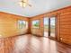 Spacious living room with wood paneled walls, glossy floors, and access to a balcony with scenic views at 11766 Coal Creek Heights Dr, Golden, CO 80403