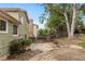 Landscaped backyard with a paved patio area, trees, and a wooden fence, providing privacy and space at 18625 E Kent Dr, Aurora, CO 80013