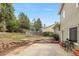 A spacious backyard featuring a patio, tiered garden beds, and mature trees, perfect for outdoor living at 18625 E Kent Dr, Aurora, CO 80013