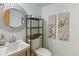 Well-appointed half bathroom with stylish mirror, decorative shelving, and modern fixtures at 18625 E Kent Dr, Aurora, CO 80013