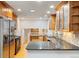 Spacious kitchen with granite countertops, wood cabinetry, and modern appliances at 18625 E Kent Dr, Aurora, CO 80013