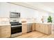 Modern kitchen with white cabinets, stainless steel appliances, and light wood flooring at 2105 S Galapago St # 4, Denver, CO 80223