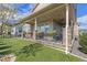 Covered back porch with stone accents, artificial turf, and a black metal fence at 3214 Heron Lakes Pkwy, Berthoud, CO 80513