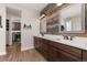 Elegant bathroom featuring double sinks, dark wood cabinetry and modern lighting at 3214 Heron Lakes Pkwy, Berthoud, CO 80513