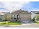 Tan house with gray roof, two-car garage, and landscaped yard at 3214 Heron Lakes Pkwy, Berthoud, CO 80513