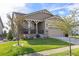 Charming home featuring a well-manicured lawn, stone accents, and a cozy covered porch at 3214 Heron Lakes Pkwy, Berthoud, CO 80513