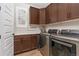 A laundry room with stainless steel washer and dryer, cabinets, and a window at 3214 Heron Lakes Pkwy, Berthoud, CO 80513