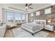 Stylish main bedroom with modern furnishings, wood accent wall and natural light at 3214 Heron Lakes Pkwy, Berthoud, CO 80513