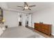 Spacious main bedroom featuring a ceiling fan, wood floors, wood accent wall and en-suite bathroom at 3214 Heron Lakes Pkwy, Berthoud, CO 80513