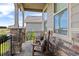 Relaxing porch featuring stone pillars, two rocking chairs and comfortable pillows at 3214 Heron Lakes Pkwy, Berthoud, CO 80513