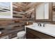 Stylish powder room featuring wood accent wall, modern fixtures and a mirror at 3214 Heron Lakes Pkwy, Berthoud, CO 80513