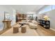 Bright living room featuring a curved sofa, woven stools, and views of the modern kitchen at 4127 Tejon St, Denver, CO 80211