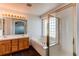 Bright bathroom features double sinks, vanity, bathtub with glass block window, and walk-in shower at 10486 Cheetah Winds, Lone Tree, CO 80124