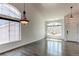 Spacious open floor plan with hardwood floors, large windows, and stylish lighting fixtures at 10486 Cheetah Winds, Lone Tree, CO 80124