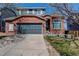 Charming brick home featuring a two-car garage and a well-maintained front yard at 10486 Cheetah Winds, Lone Tree, CO 80124