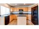 Bright kitchen features light wood cabinets, black countertops, island, and stainless steel appliances at 10486 Cheetah Winds, Lone Tree, CO 80124
