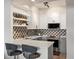 Updated kitchen features stainless appliances, grey and white cabinets, quartz countertops, and decorative backsplash at 345 Fillmore # 407, Denver, CO 80206