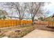 Spacious backyard with a wooden fence, fire pit, and established trees at 8970 Garland Ct, Westminster, CO 80021