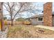 Large backyard with a brick chimney, wooden fence, and a swing at 8970 Garland Ct, Westminster, CO 80021