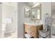 Bright bathroom with wood vanity, large mirror, and tiled shower with glass door at 8970 Garland Ct, Westminster, CO 80021
