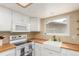 Bright kitchen boasts white cabinets, butcher block countertops, and stainless steel appliances at 8970 Garland Ct, Westminster, CO 80021