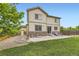 Tan home with patio, stone accents, a detached garage, and a well-maintained lawn at 6108 S Harvest Ct, Aurora, CO 80016