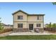 Tan two-story home featuring a patio and a mix of stone and wood siding accents at 6108 S Harvest Ct, Aurora, CO 80016