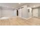 Spacious finished basement with wood-look flooring, recessed lighting, and stylish sliding barn doors at 6108 S Harvest Ct, Aurora, CO 80016