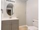Cozy half bathroom featuring a modern vanity and stylish oval mirror at 6108 S Harvest Ct, Aurora, CO 80016
