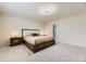 Carpeted bedroom featuring a king bed, side tables, and adjacent bathroom at 6108 S Harvest Ct, Aurora, CO 80016
