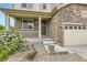 Inviting front porch with stone accents, decorative plants, and well-maintained landscaping at 6108 S Harvest Ct, Aurora, CO 80016