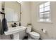 A classic powder room features a pedestal sink, sleek black faucet and a modern rectangular mirror at 6108 S Harvest Ct, Aurora, CO 80016