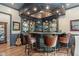 Home bar featuring a dark wood design, recessed lighting, shelving and three leather chairs at 1350 E Greenwood Ln, Greenwood Village, CO 80121