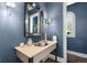 Stylish powder room with blue walls, decorative mirror, and vessel sink on a stone countertop at 1350 E Greenwood Ln, Greenwood Village, CO 80121