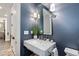 Stylish powder room with blue walls, elegant vanity, chrome fixtures, and decorative mirror at 1350 E Greenwood Ln, Greenwood Village, CO 80121