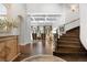 Grand foyer featuring hardwood floors, a curved staircase with iron railing, and coffered ceilings at 1350 E Greenwood Ln, Greenwood Village, CO 80121