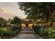 Inviting home facade with stone pathway, manicured shrubs, and architectural lighting at dusk at 1350 E Greenwood Ln, Greenwood Village, CO 80121