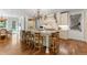 Bright kitchen featuring hardwood floors, a large island with counter seating, and white cabinetry with stone countertops at 1350 E Greenwood Ln, Greenwood Village, CO 80121