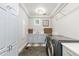 Well-lit laundry room boasts side by side machines, gray shaker cabinets, and slate flooring at 1350 E Greenwood Ln, Greenwood Village, CO 80121