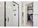 Bright bathroom featuring a glass enclosed shower with dark fixtures, marbled tile, and walk in closet at 12270 W 57Th Ave, Arvada, CO 80002
