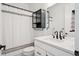 Charming bathroom with a white vanity, matte black hardware, subway tile, and glass door cabinet at 12270 W 57Th Ave, Arvada, CO 80002