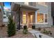 Charming front porch featuring a hanging chair, modern door, and lovely landscaping at 12270 W 57Th Ave, Arvada, CO 80002