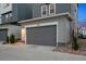 Attached garage with a gray door and visible house number; nestled in a landscaped yard at 12270 W 57Th Ave, Arvada, CO 80002
